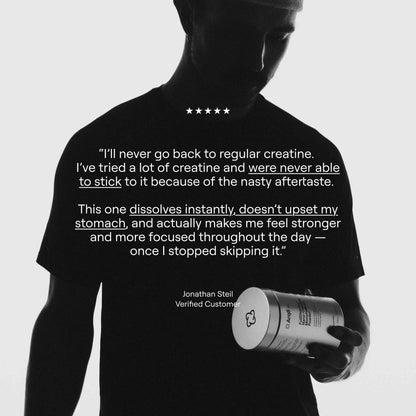 Person holding a supplement container with a customer review on a black t-shirt against a white background