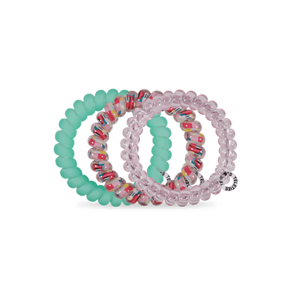 TELETIES Spring Splash large coil hair ties in pink, speckled clear and mint green, on a green background