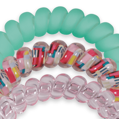 Colorful spiral hair ties on a green background