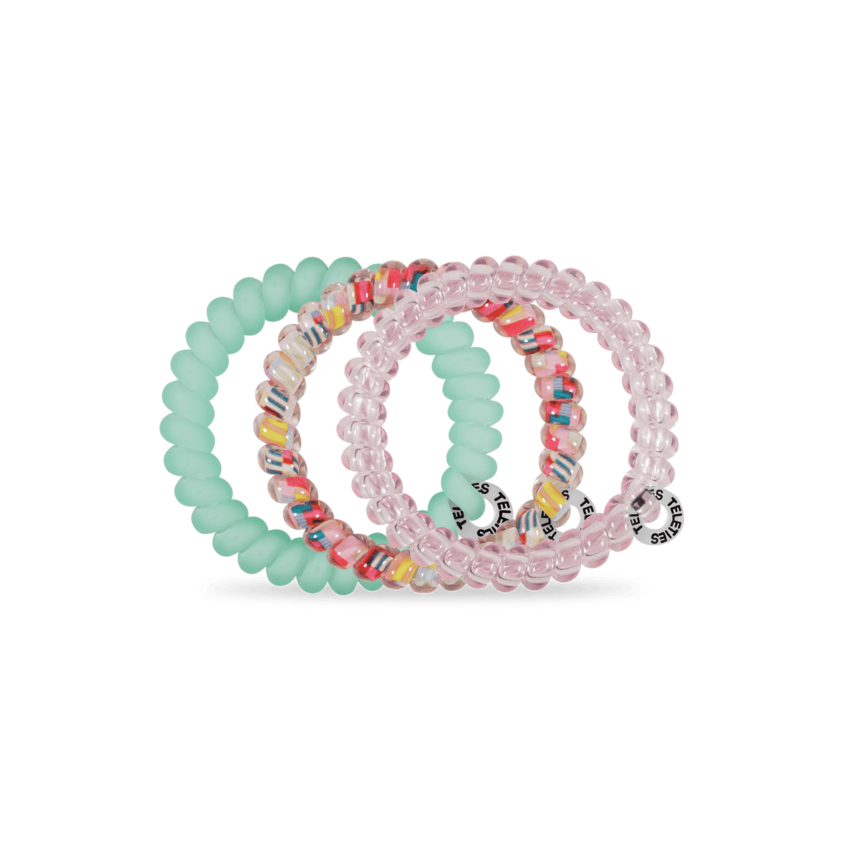 TELETIES Spring Splash small coil hair ties in three colors on a green background