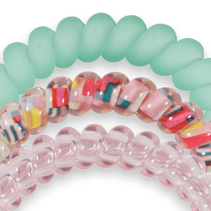 Colorful spiral hair ties on a green background