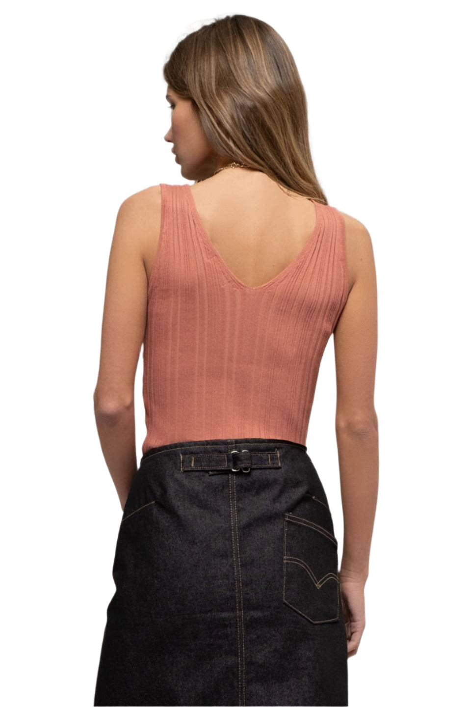 Woman wearing a pink sleeveless top and black denim skirt on a white background