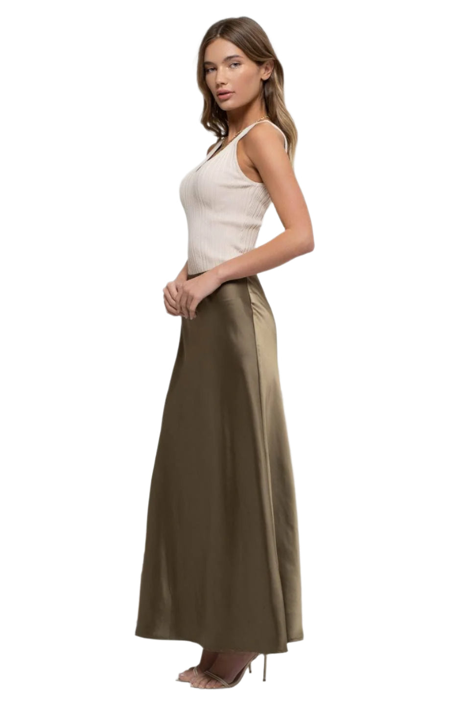 Woman wearing a white top and long brown skirt on a white background