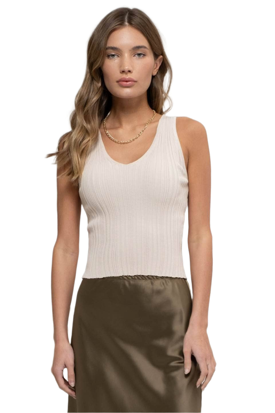 Woman wearing a beige ribbed tank top and brown satin skirt on a white background