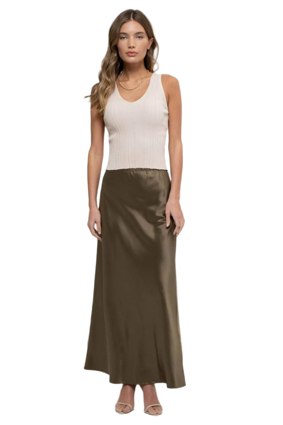 Woman wearing a white sleeveless top and brown satin skirt on a white background