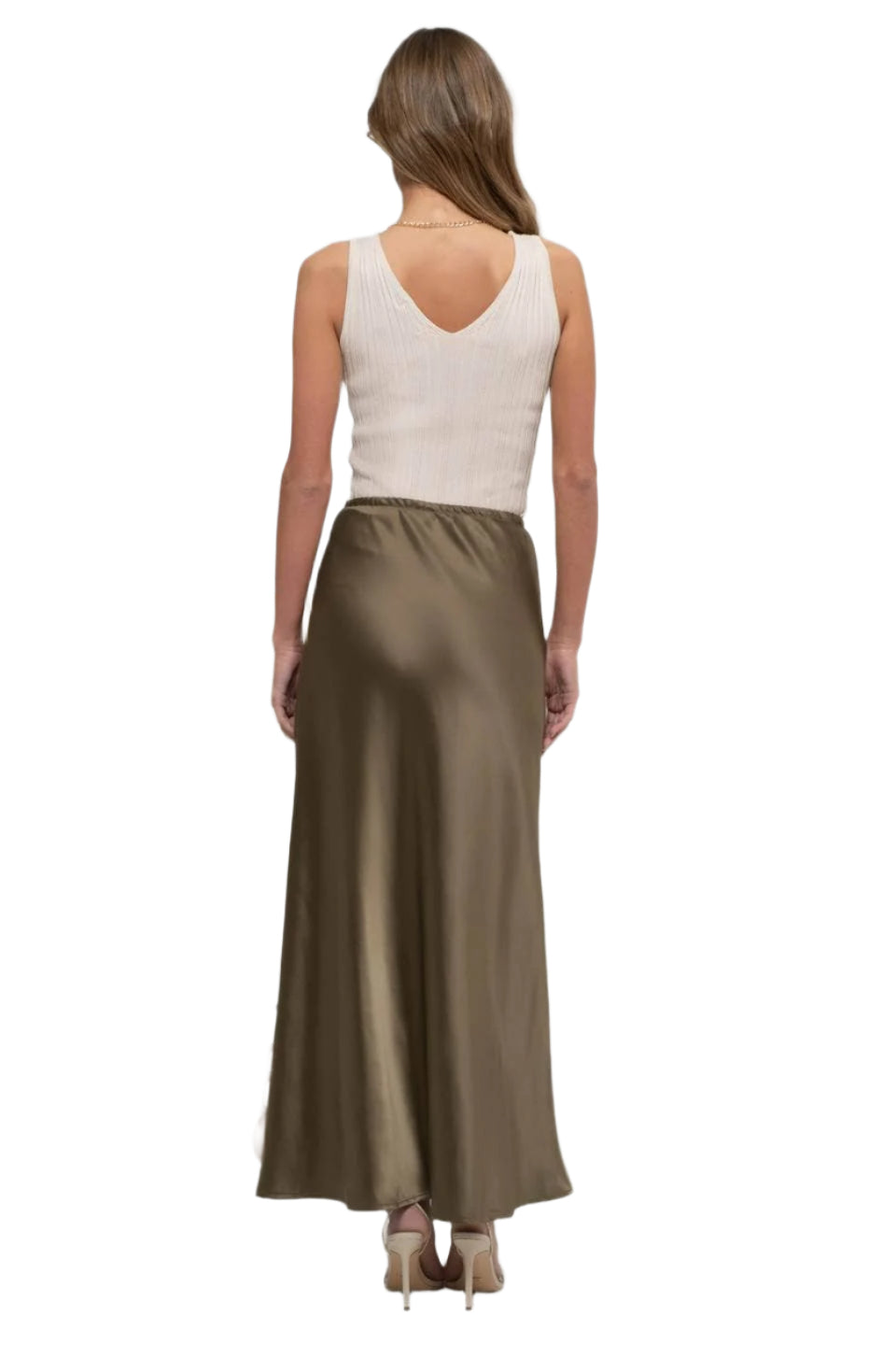 Woman wearing a long satin skirt and white top on a white background