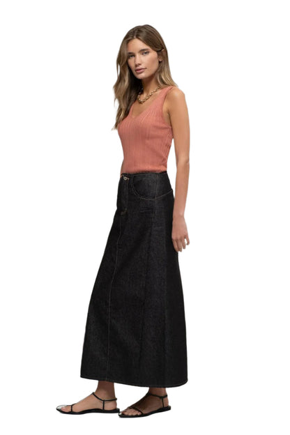 Woman wearing a pink top and black skirt on a white background