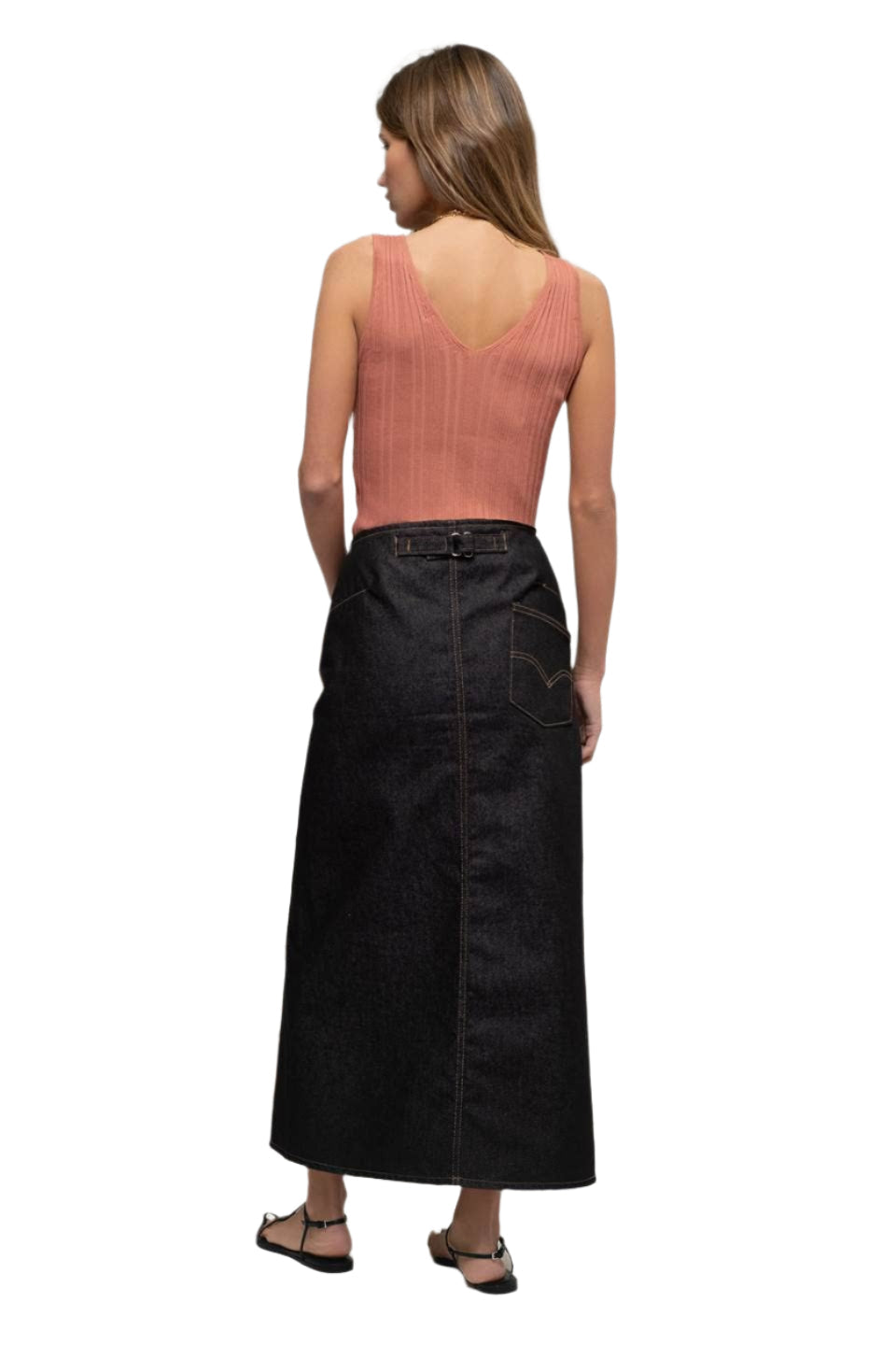 Woman wearing a long black skirt and pink top on a white background