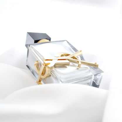 Yves Saint Laurent Libre L'Absolu Platine Parfum bottle in clear glass with gold detail on a white background
